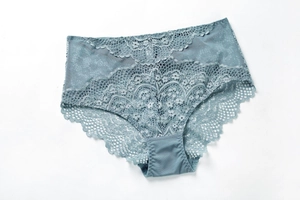 Detail of misty blue lace panties with delicate floral patterns and mesh side panels