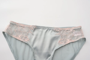 Close-up of blue satin panties with pink floral lace trim and soft fabric texture