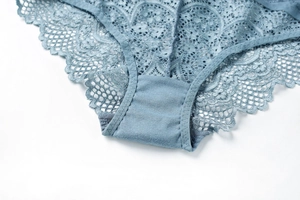 Detailed close-up of dark blue floral lace underwear featuring elegant wavy scalloped edges