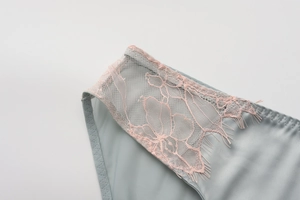 Macro shot of French eyelash lace and light cyan satin fabric with detailed stitching