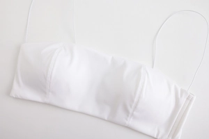 Dettaglio del reggiseno a fascia bianco senza cuciture con spalline sottili e cuciture fini