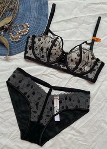 Detalle de sujetador de encaje negro con bordado floral y tirantes cruzados sexy