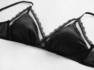 Close-up of black triangle bra featuring delicate lace trim and smooth satin fabric detail