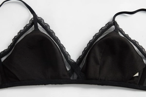 Detailed macro view of black French lace bra with semi-transparent mesh and wire-free cups