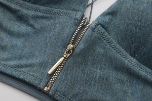 Detail of golden metal zipper on dark blue denim fabric of a wire-free triangle bra