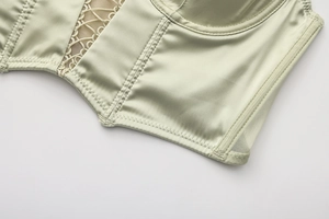 Macro di un corsetto verde chiaro che mostra la trama in raso e dettagli in mesh