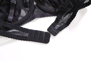 Detail view of black lace lingerie with three-row metal back hook and eye closure
