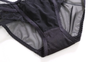 Detail shot of black lace panties with breathable sheer mesh and scalloped edges