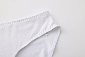 Detail shot of white seamless underwear featuring fine stitching and quality laundry tag