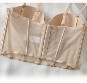 Detalle de sujetador tipo corsé beige con tejido de malla y varillas de soporte