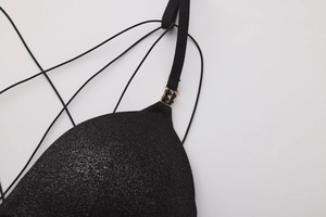 Detail of black shimmer bra cup with gold buckle and black gem embellishment