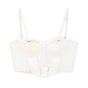 Dettaglio di reggiseno a corsetto in pizzo bianco con ricami e fibbie dorate regolabili
