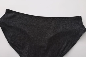 Close-up of black seamless bikini bottom with sparkling metallic glitter fabric detail