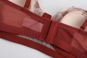 Detalle del sujetador de encaje rojo con tirantes ajustables y costura ondulada
