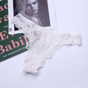 Detailed view of white floral lace thong with semi-transparent polka dot mesh texture