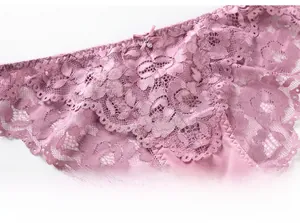 Gros plan sur une culotte en dentelle violette avec nœud délicat et pendentif cristal