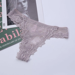 Detail of mauve lace thong with floral edges and polka dot mesh on magazine background