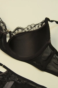 Close-up of black floral lace bra with sheer mesh and delicate scalloped edge detail