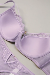 Detail of purple lace lingerie set with floral embroidery and gold metal hardware