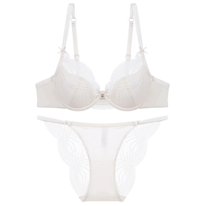 Detailweergave van crème kant lingerie set met strikjes en een kristallen hanger