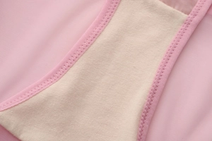 Detalle de ropa interior de malla rosa con refuerzo de algodón y costuras en zigzag