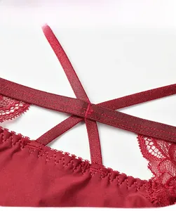 Detailed close-up of wine red lace underwear with elastic cross straps and silk fabric