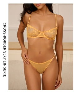 Macro shot of ginger yellow floral embroidery on sheer lace bra and thong set