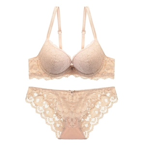 Close-up of beige lace bra set showing intricate floral patterns and delicate bow detail