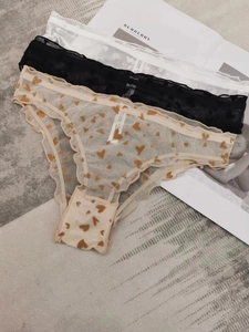 Close-up of three lace mesh panties in white, black and heart print with cotton crotch