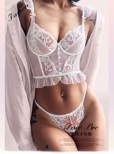 Detail van wit bloemenborduurwerk en ruches op deze kanten lingerie set voor dames