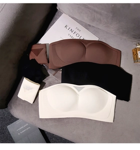 Flat lay of seamless strapless bras and matching panties in brown, black and beige colors