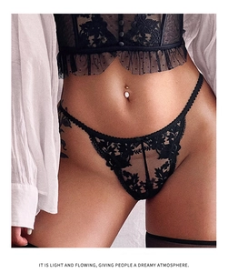 Detail van zwarte kanten lingerieset met bloemenborduurwerk en geschulpte rand