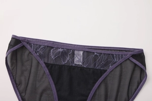 Detalle de bordado floral de encaje morado y malla transparente en bragas de mujer