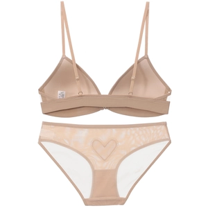 Detalle de conjunto de lencería de encaje beige con corte en forma de corazón detrás