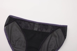 Detalle de bragas de encaje negro con borde elástico morado y detalles florales