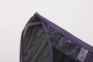 Vista macro de encaje floral morado y malla negra en esta braguita sexy para mujer