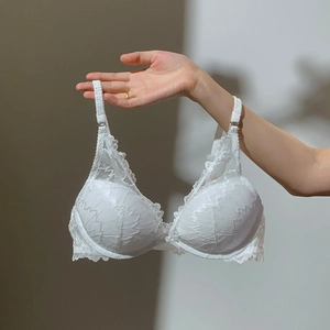 Close-up of white floral lace bra detail with delicate adjustable straps and textures