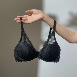 Detailed macro view of black floral lace bra with delicate bow and scalloped edge