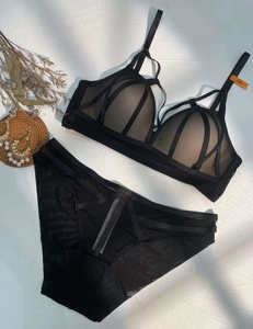 Flachbild von schwarzem Mesh-Dessous-Set mit Kreuzgurtdetails und Spitzenakzenten