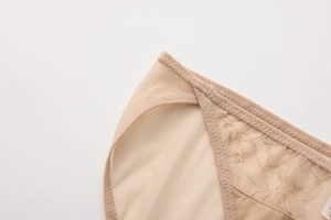 Primer plano de ropa interior de encaje beige con bordado floral y costura en zig-zag