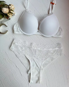 Détail d'un soutien-gorge blanc avec bonnets lisses et empiècements en dentelle florale