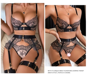 Detail of black eyelash lace and satin lingerie set with gold hardware and garters