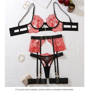 Detail of red floral eyelash lace lingerie set with suspenders and gold buckles