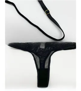 Détail d'un string en maille noire transparente avec des boucles de réglage dorées