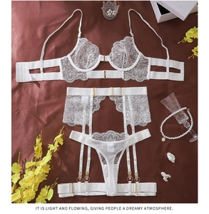 Detail of white eyelash lace lingerie set featuring floral mesh and gold metal buckles