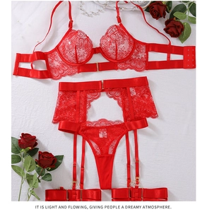Flat lay of red lace lingerie set featuring underwire bra and garter belt with floral detail