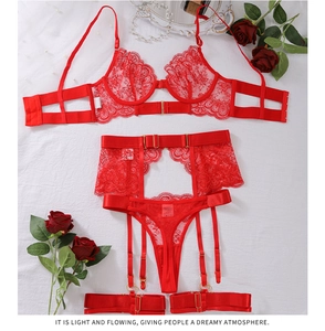 Detail of red floral lace lingerie set with metal buckles on white fabric background