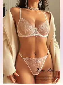 Détails d'un ensemble lingerie en dentelle blanche avec broderie rose et boucle or