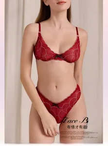 Detail of red lace lingerie set featuring delicate embroidery and elegant black bow accents