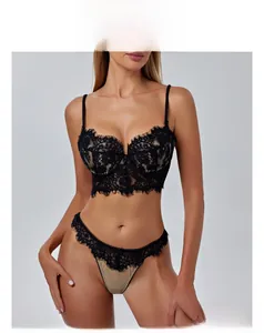 Detalle de conjunto de lencería de encaje negro con sujetador push-up y tanga a juego en modelo